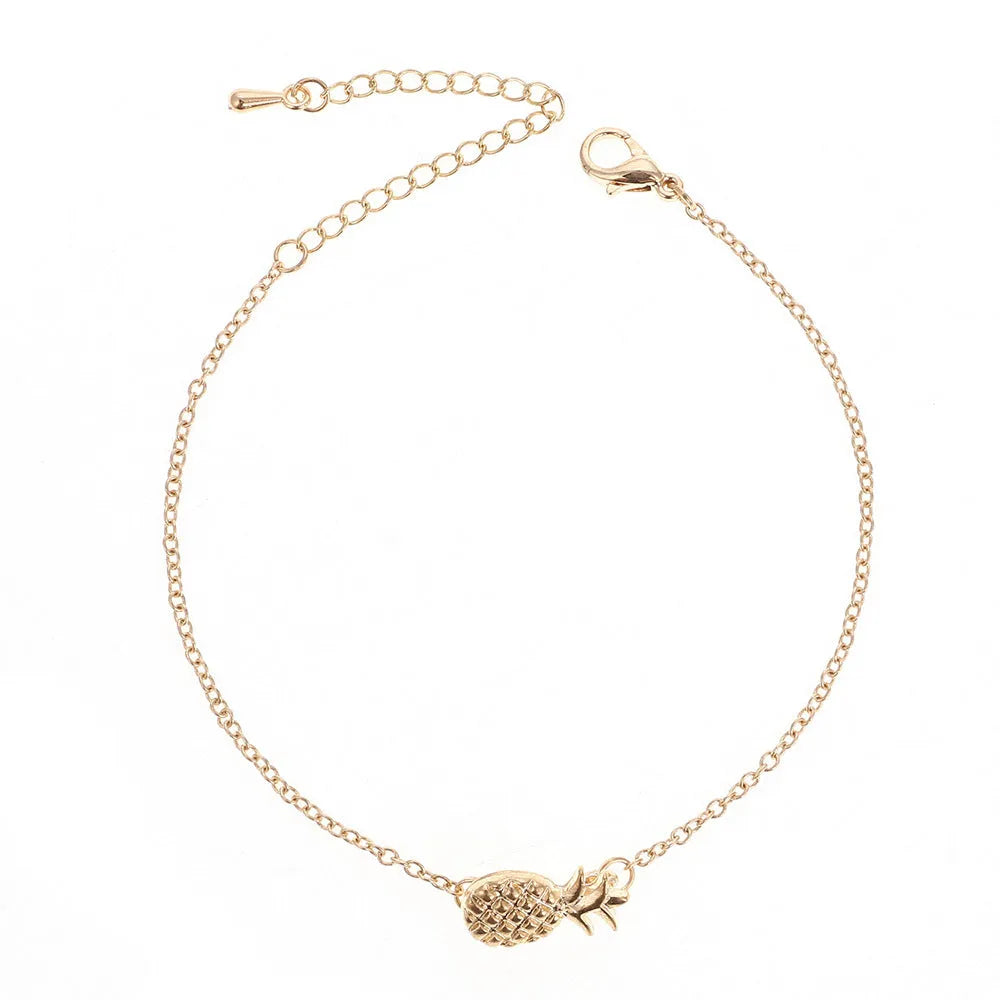 Women's alloy pineapple charm bracelet in gold or silver colour on a wrist.