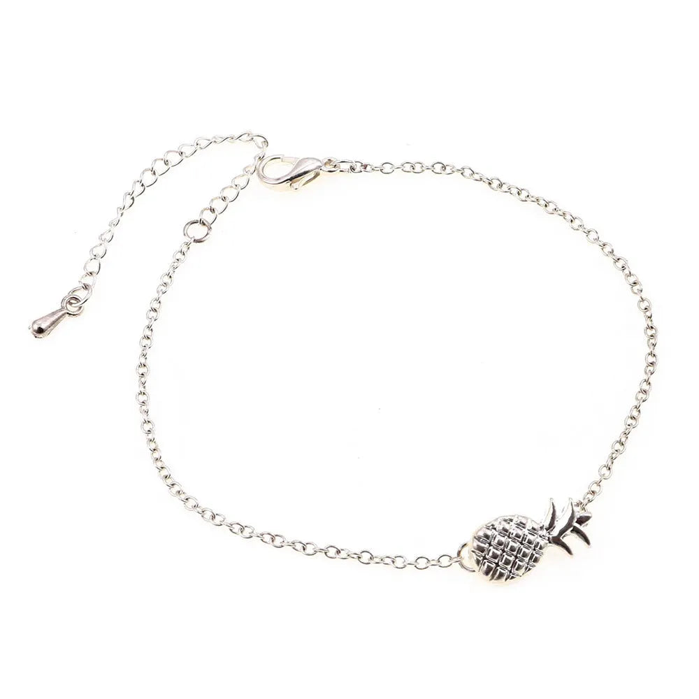 Women's alloy pineapple charm bracelet in gold or silver colour on a wrist.