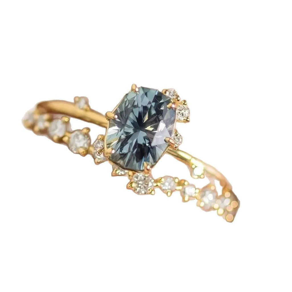 A pair of gold-plated floral rings with a central green zircon stone on a white background.