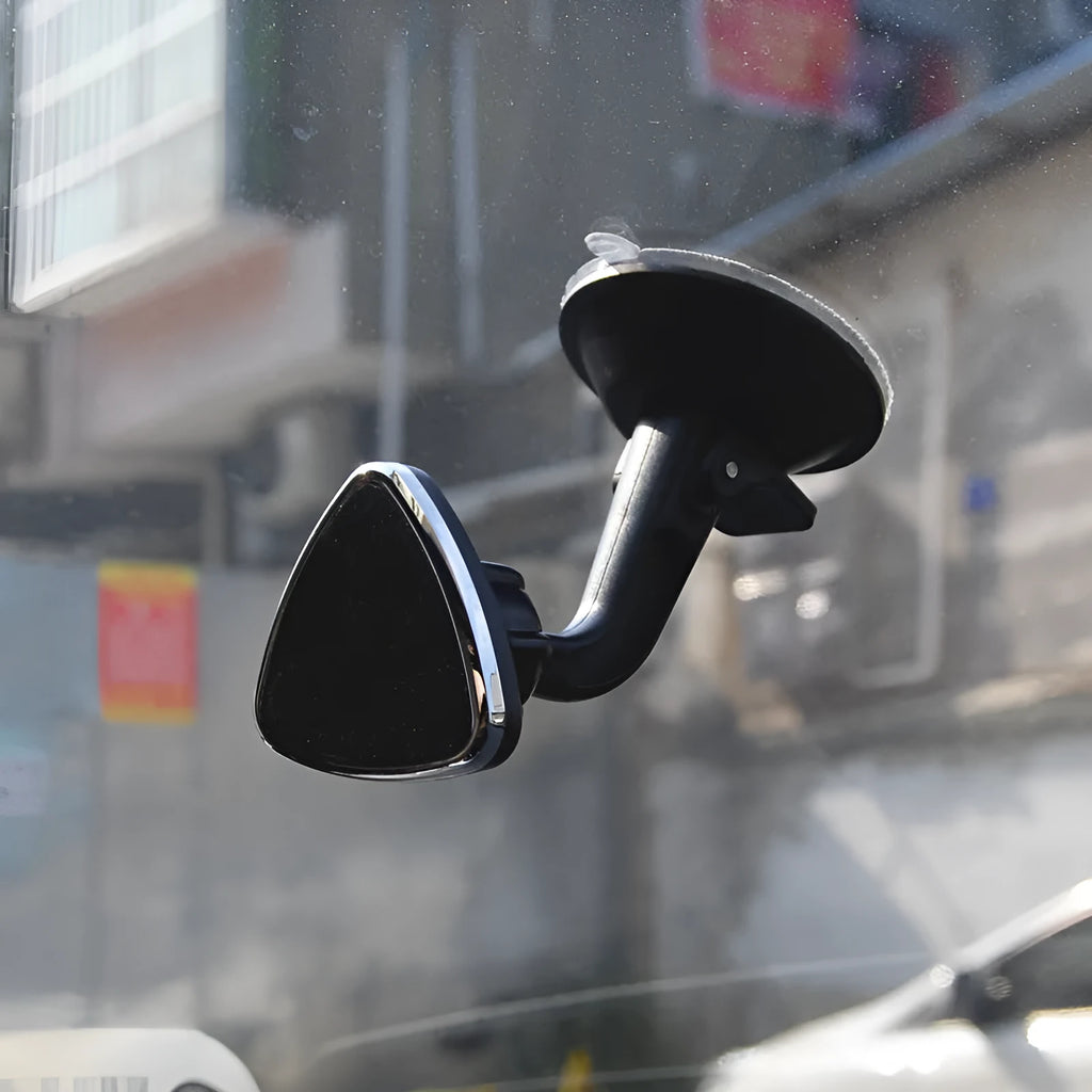 Black magnetic car phone holder mounted on dashboard with phone attached, showing 360-degree rotation capability