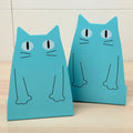 Pair of iron bookends in blue colour on a shelf holding books upright