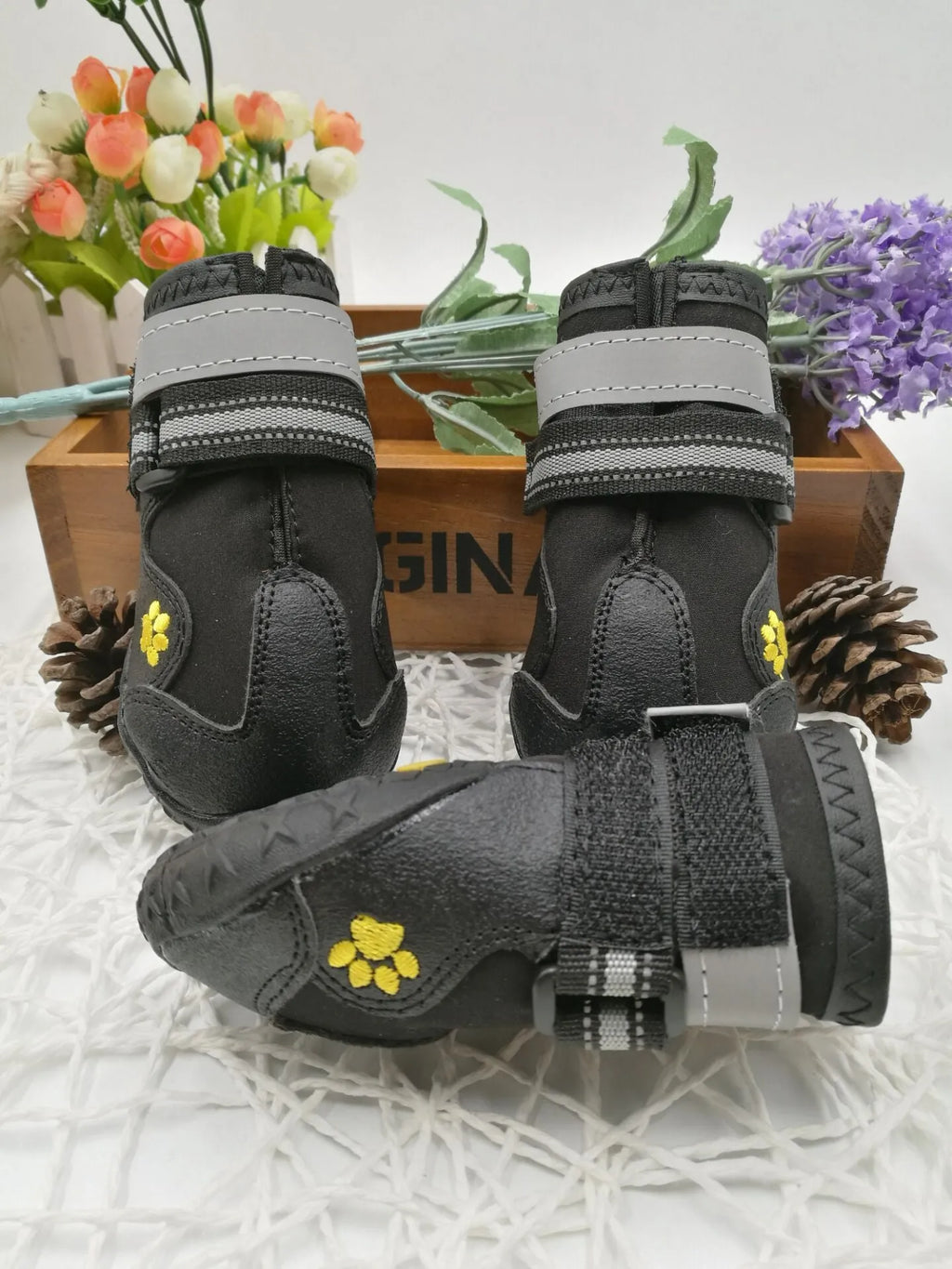 Black dog shoes with waterproof PVC sole and adjustable fuzzy belt on a white background