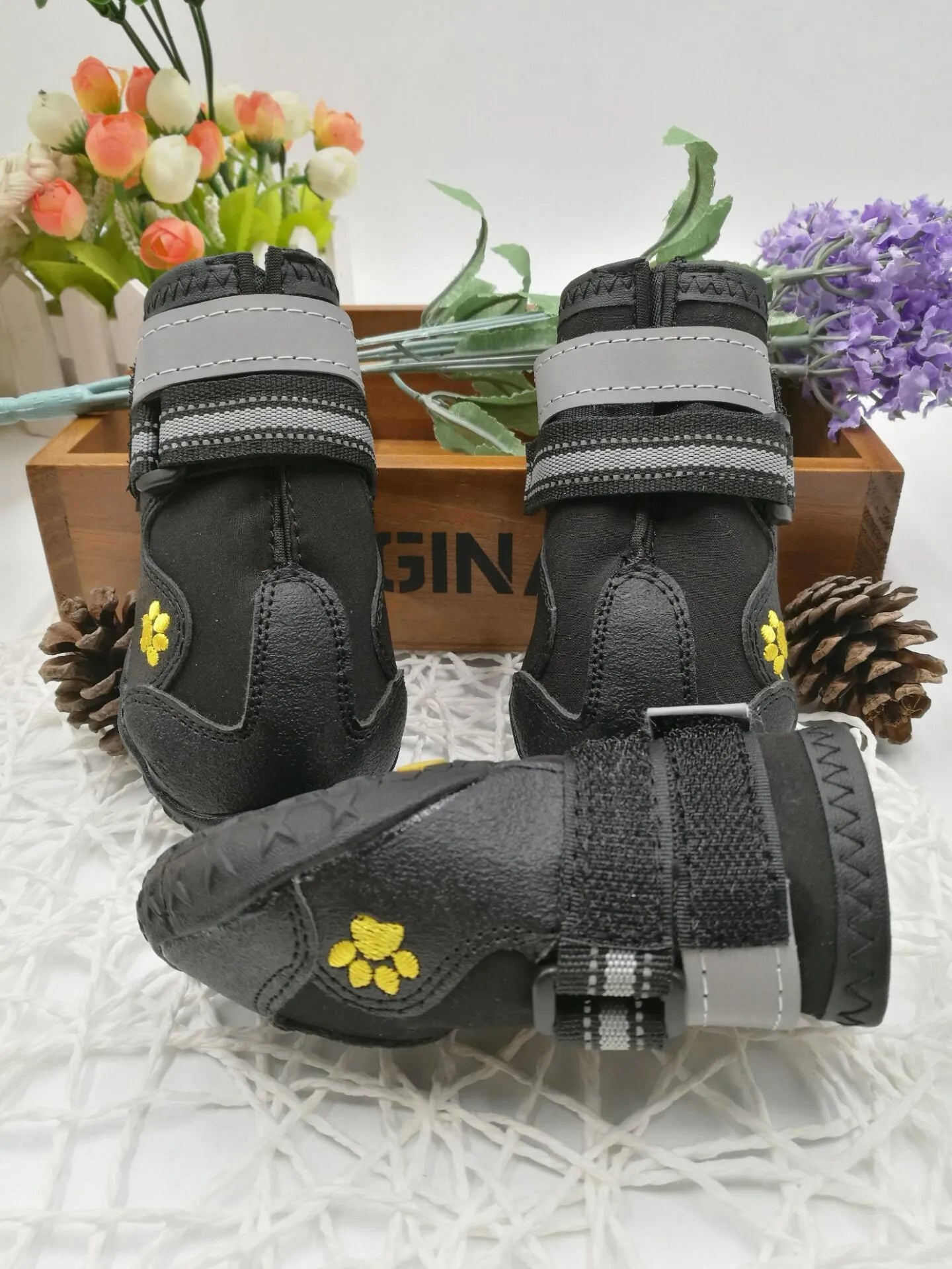 Black dog shoes with waterproof PVC sole and adjustable fuzzy belt on a white background