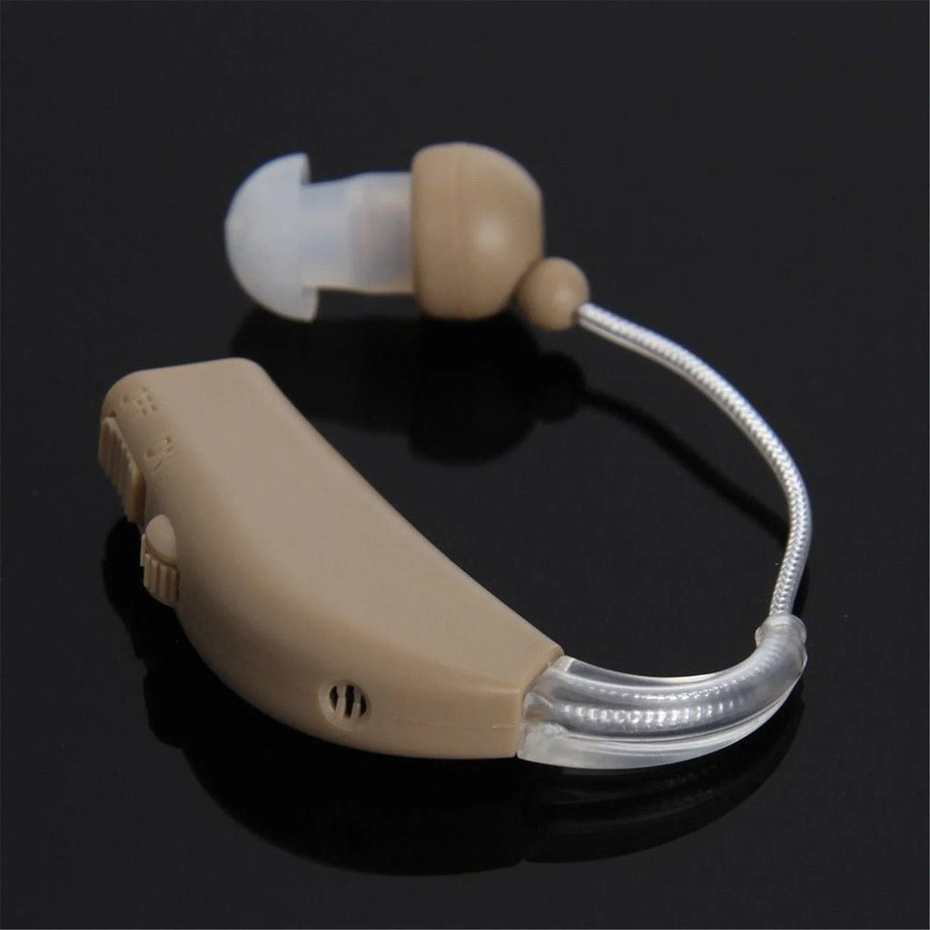 Small white rechargeable BTE hearing aid amplifier with charging cable, shown with EU and US plug options.