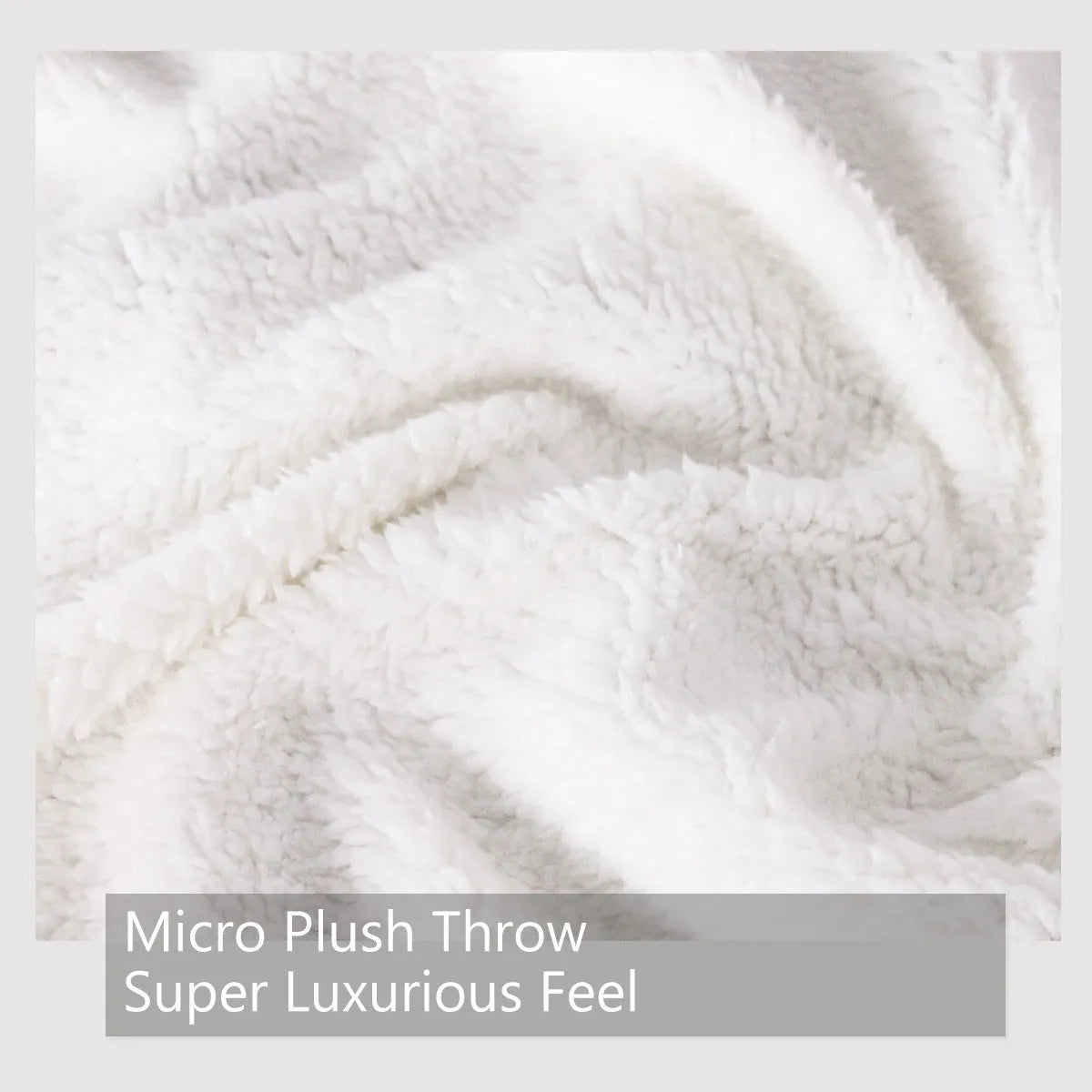 Black sherpa fleece blanket folded on a couch, soft fabric with hemmed edges.