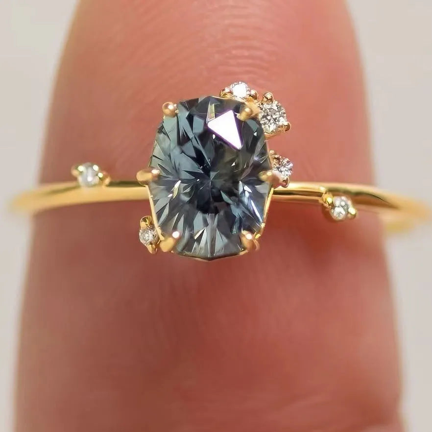 A pair of gold-plated floral rings with a central green zircon stone on a white background.