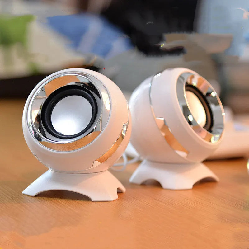 Compact black and gold USB-powered stereo desktop speakers next to a laptop.