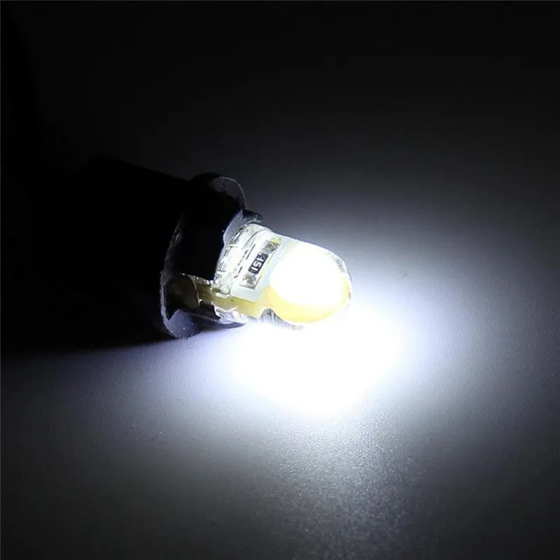 Ten silicone T10 LED car bulbs in various colours including white, red, blue, and yellow on a white background.