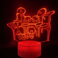 3D acrylic drum kit night light showing seven colour LED illumination on a desk