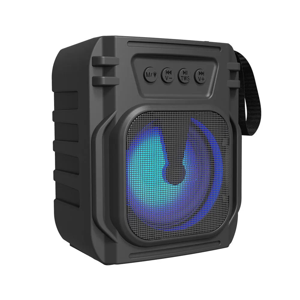 Compact portable Bluetooth speaker with USB charging cable on a desk.