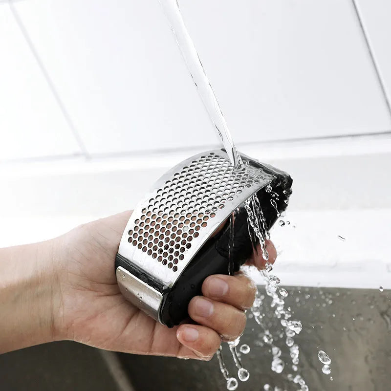 Silver 304 stainless steel garlic press with ergonomic ABS handle on a kitchen counter