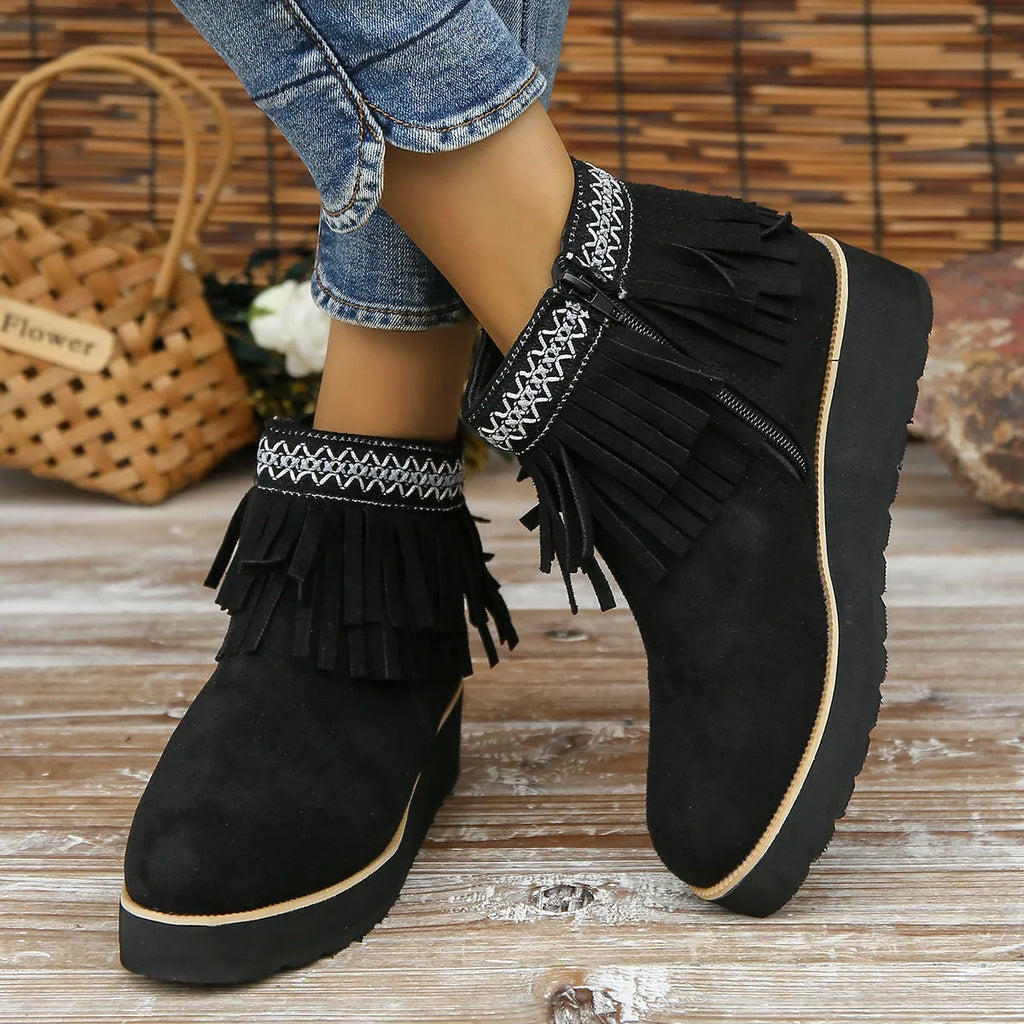 Women's black suede thick sole wedge ankle boots with side zip and tassel detail.