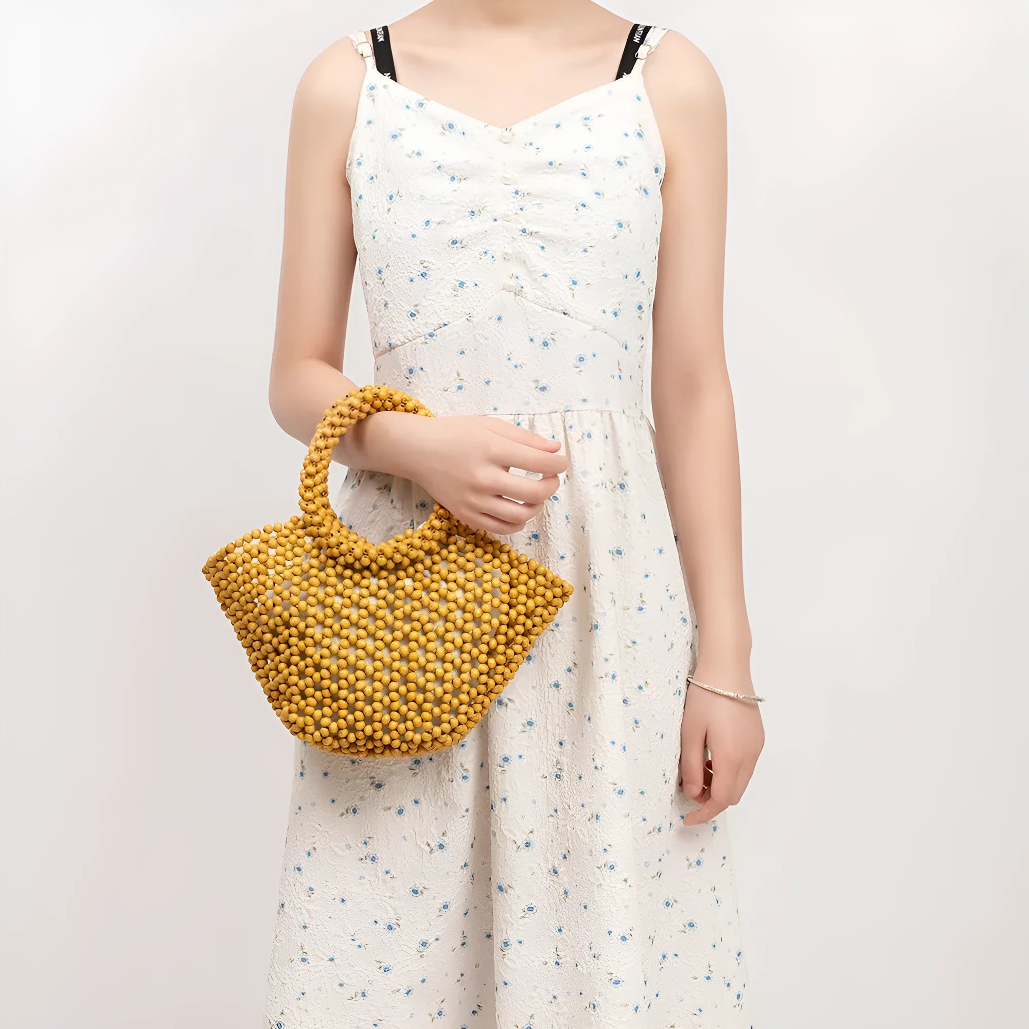Maple wood woven dumpling-shaped handbag with wooden bead decoration, shown in milky white.