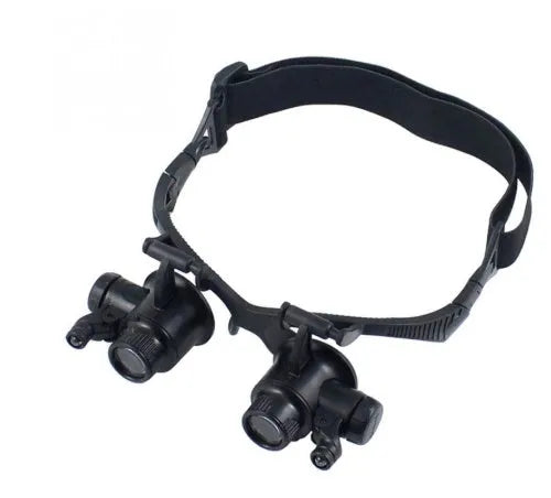 Double eye LED magnifier glasses with headband and 4 interchangeable lenses on black background