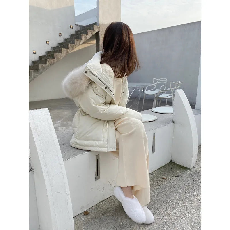 Woman wearing high-waist cream knitted wide-leg trousers with a floor-length, straight-leg silhouette.