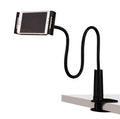 Black oversize flat panel phone stand with a long adjustable arm on a wooden table.
