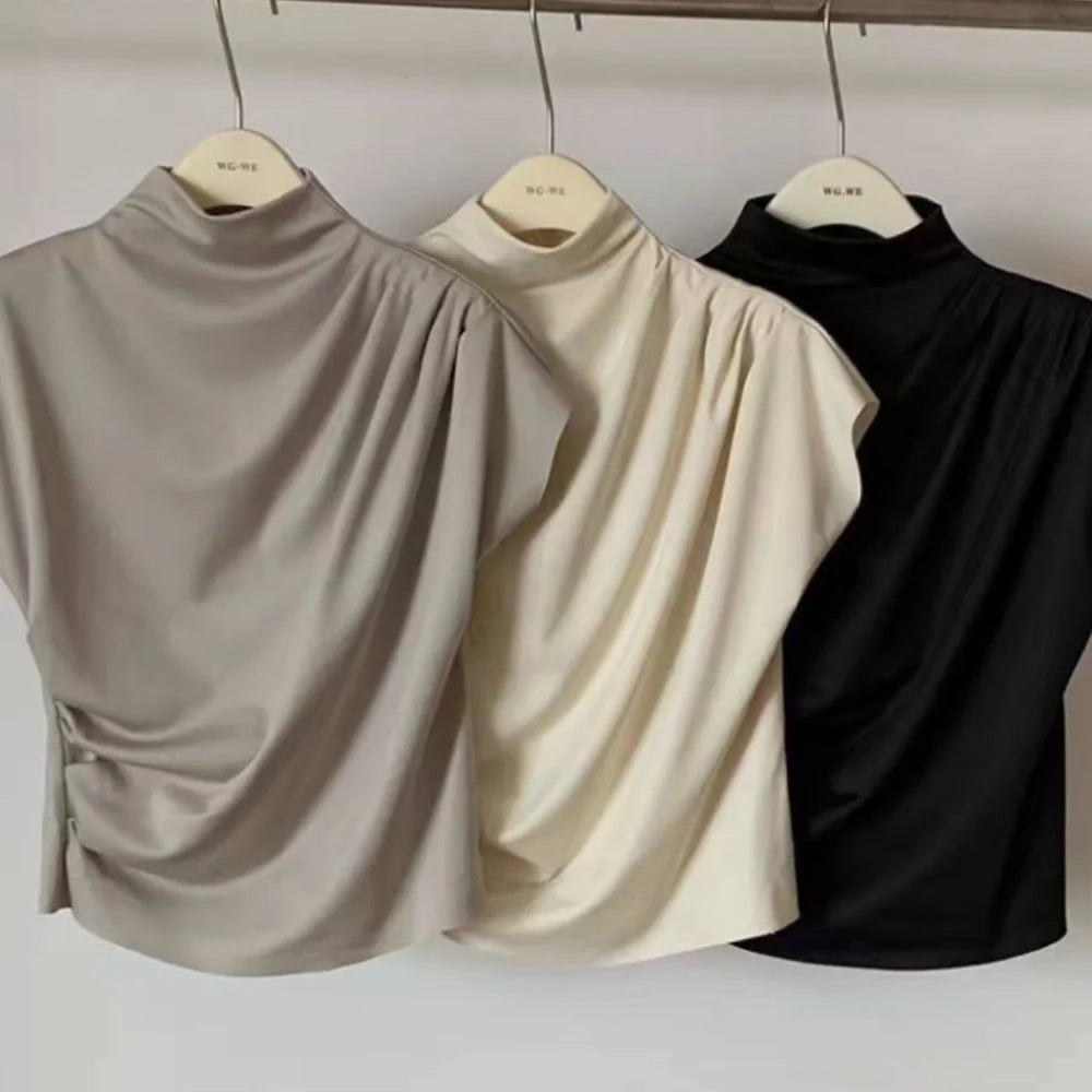 Women's apricot shirt with stand-up collar, diagonal pleats, and flowing short sleeves on hanger