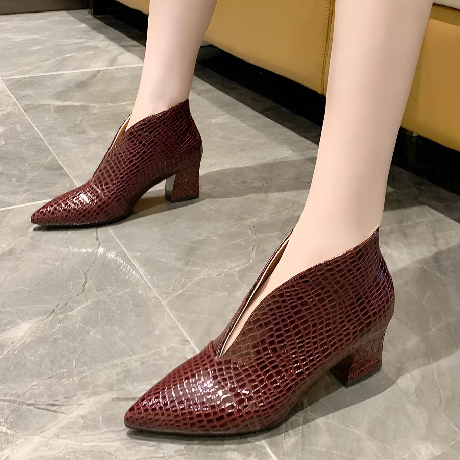 Women's black V-cut pointed toe ankle boots with embossed detail and a chunky block heel.