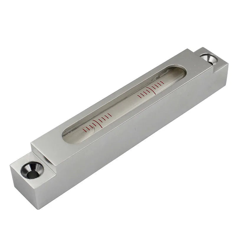 Close-up of a small metal and glass mini strip level showing bubble vials.