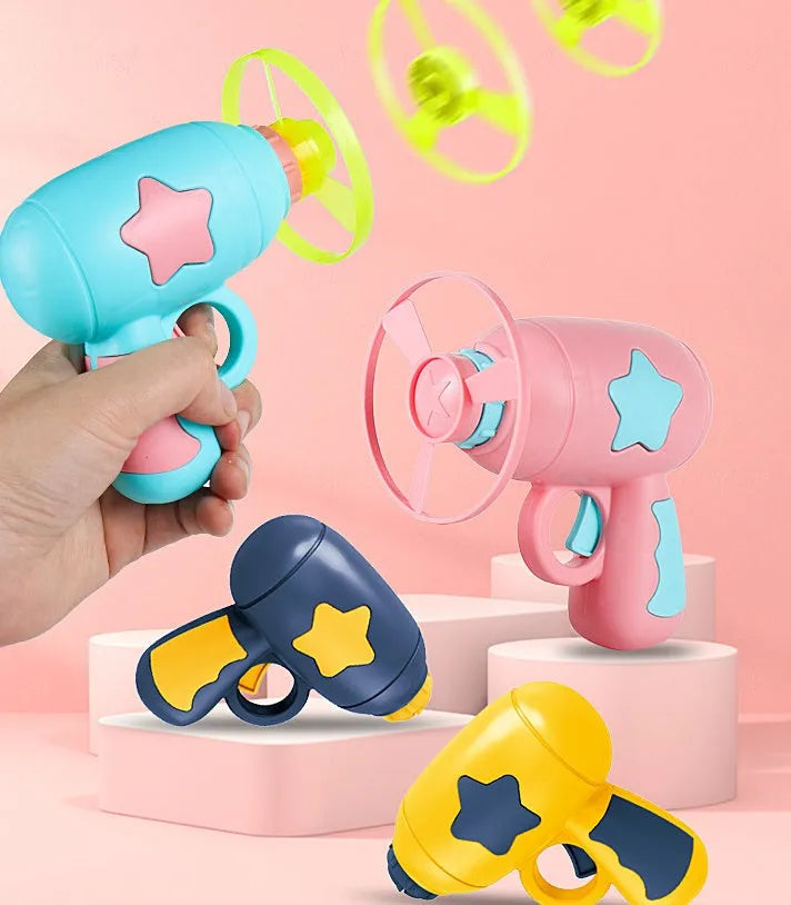 Plastic flying saucer launcher toy set with LED lights and coloured discs on outdoor grass.