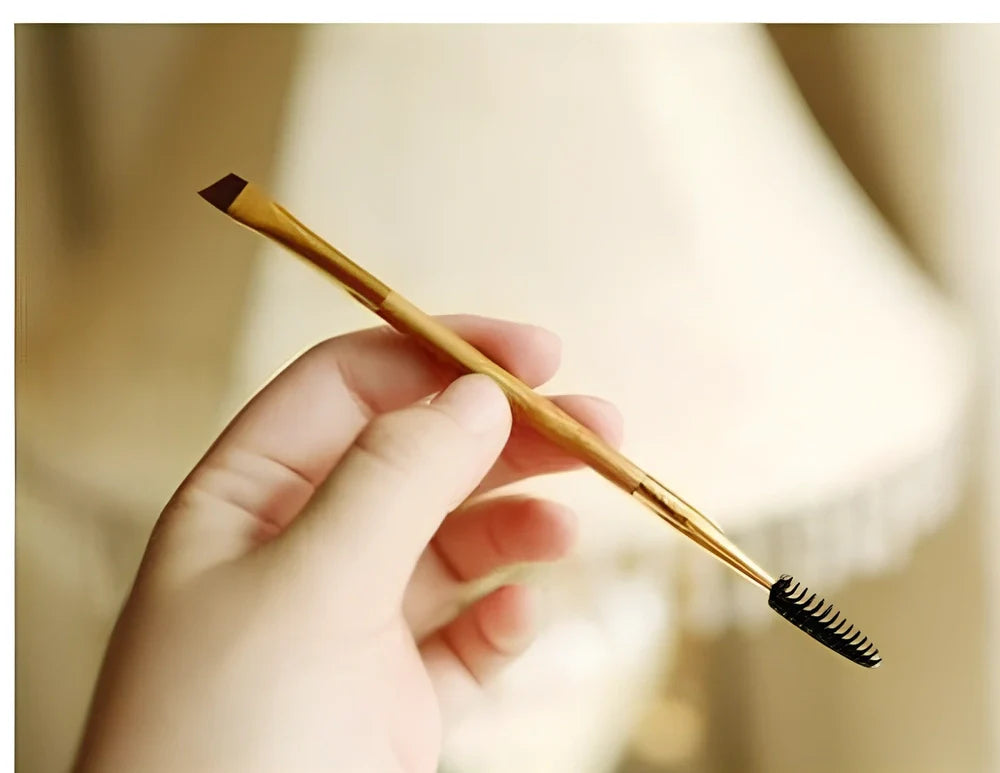 Double-ended eyebrow brush with bamboo handle and golden tube, rayon bristles for precise application and spiral head for blending brows and lashes