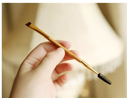 Double-ended eyebrow brush with bamboo handle and golden tube, rayon bristles for precise application and spiral head for blending brows and lashes