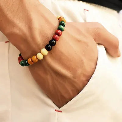 Natural stone beaded bracelet with a lava stone charm for essential oils on a wrist.
