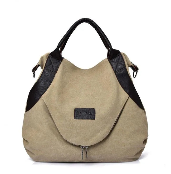 Women's canvas handbag in lake blue with zipper closure, hard handle, and double strap roots for shoulder or crossbody carry