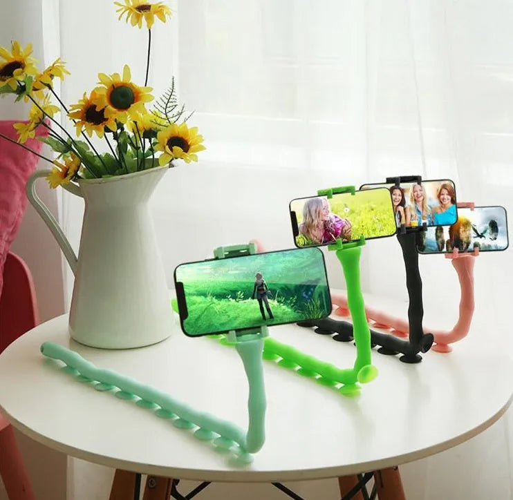 Black flexible arm phone holder with suction cup mounted on a desk, showing 360° rotation.