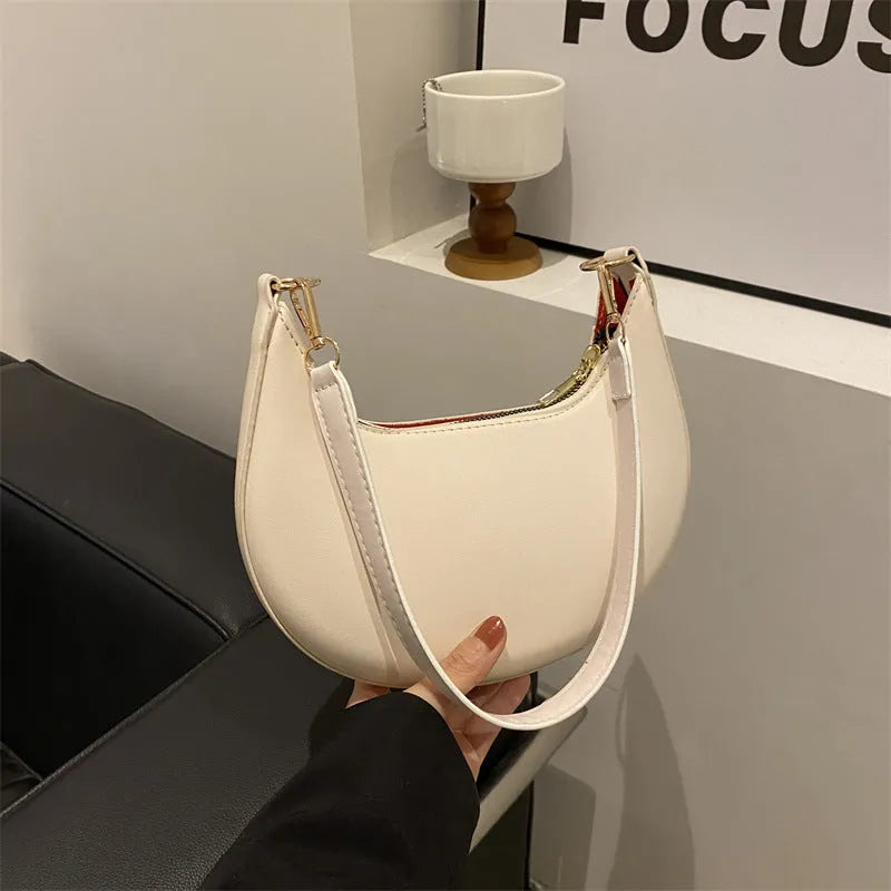 Round women's underarm bag in PU material showing sewing line detailing and internal phone compartment