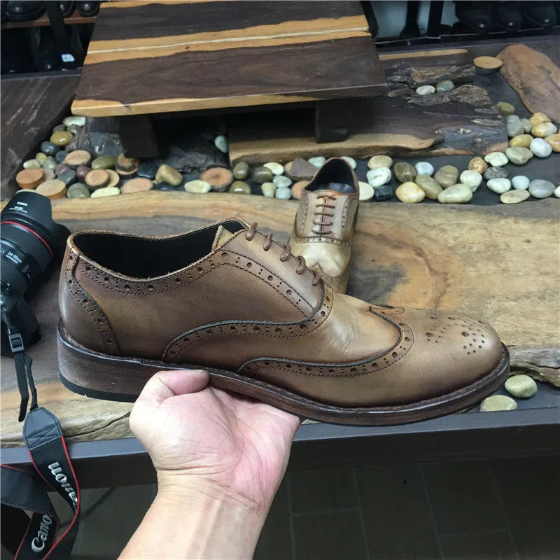 Men's light brown vintage distressed leather shoes with carved detail and round toe.