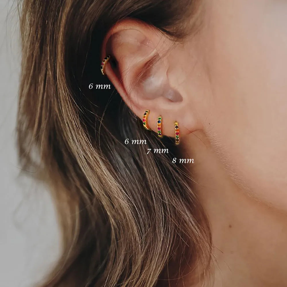 Gold, rose gold, and silver colour perforated circle zircon stud earrings in various sizes on a white background.