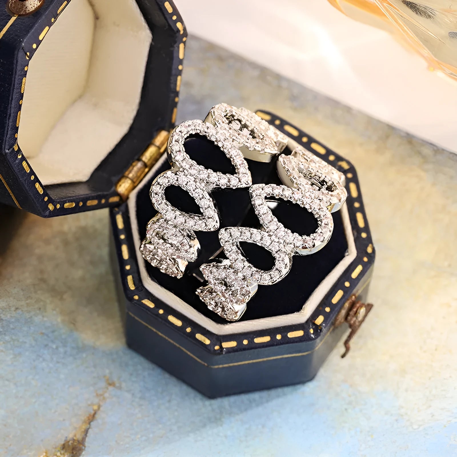 Women's gold plated copper ring with inlaid zircon stone and hexagon design on white background