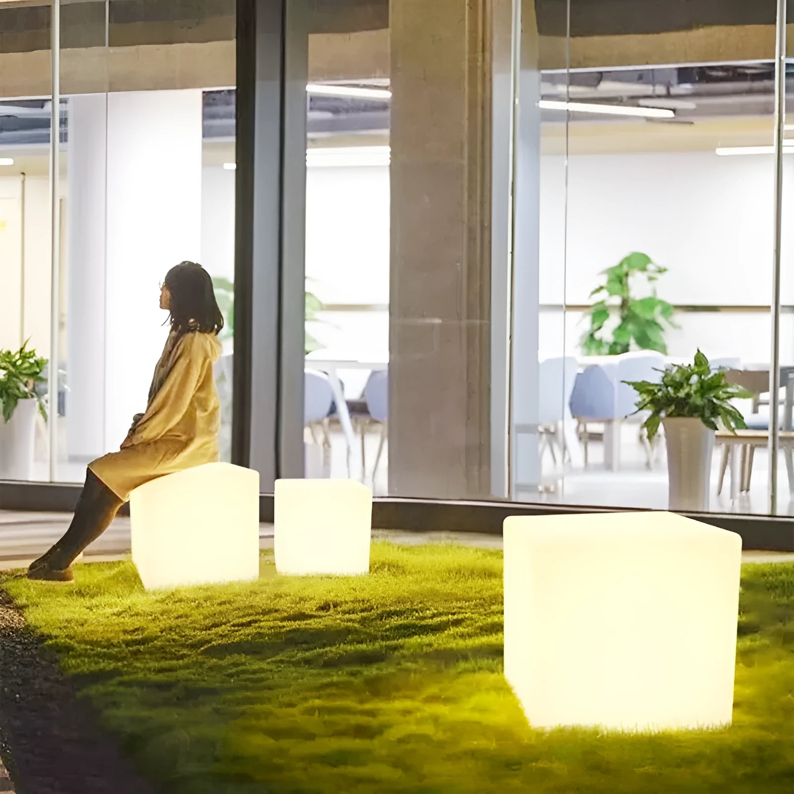 A modern white LED cube light stool sitting outdoors on a patio.