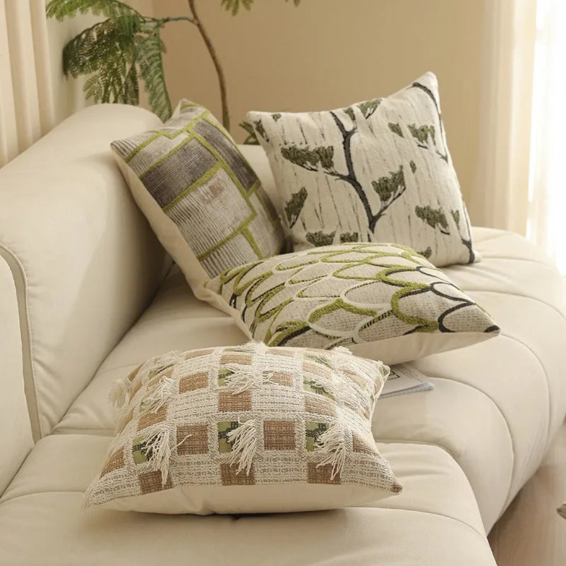 Square jacquard cushion cover with a detailed woven botanical pattern in a retro colour, shown on a grey sofa.
