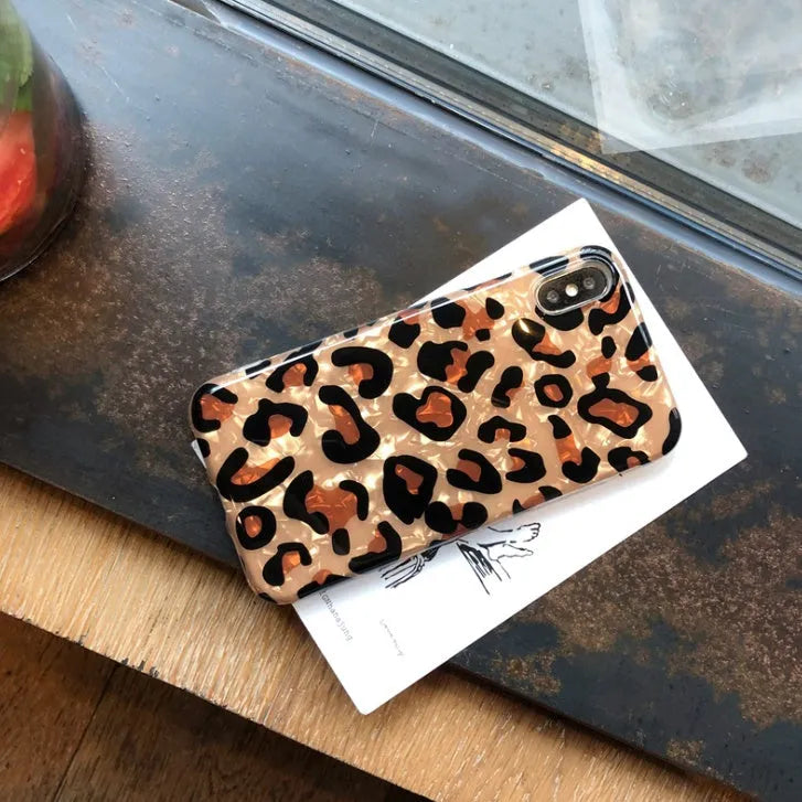 Leopard print silicone protective case for iPhone on a table.