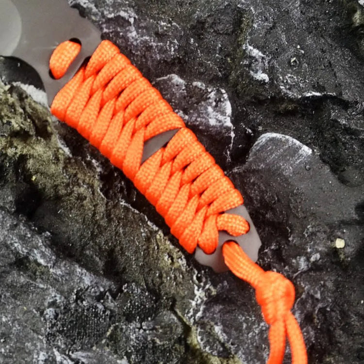 Straight survival knife with rope handle and black ABS sheath on a paper box.