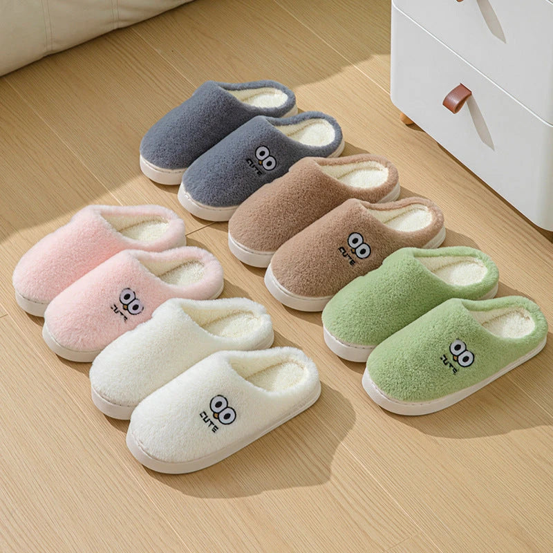 Cozy cartoon slippers with big eyes in various colors, featuring plush material and non-slip rubber soles for comfortable indoor wear