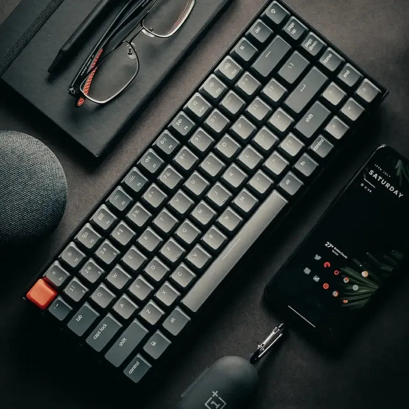 Grey 87-key mechanical keyboard with white backlight, USB and Bluetooth connectivity, compact plastic edge design