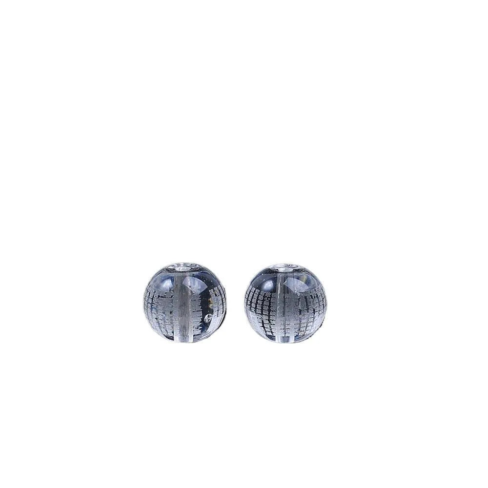 Ten 10mm round crystal prayer beads with Heart Sutra design, polished glass finish, scattered on a surface.