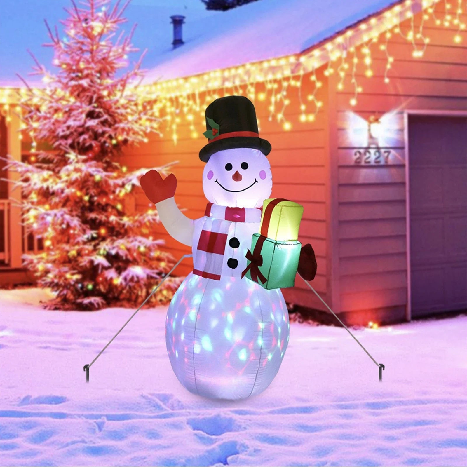 Illuminated Christmas inflatable decorations including Santa, snowman, and Christmas tree in a festive outdoor scene