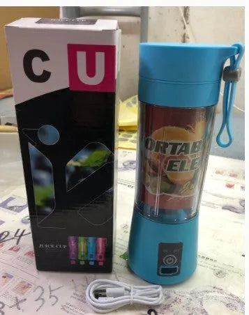 Mini USB-powered handheld fruit juicer with green plastic housing and a stainless steel blade.