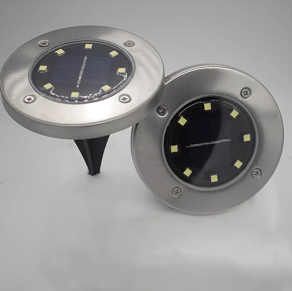 8LED waterproof solar garden light staked in lawn with warm glow, IP65 rated for rain resistance