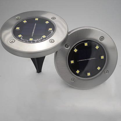 8LED waterproof solar garden light staked in lawn with warm glow, IP65 rated for rain resistance