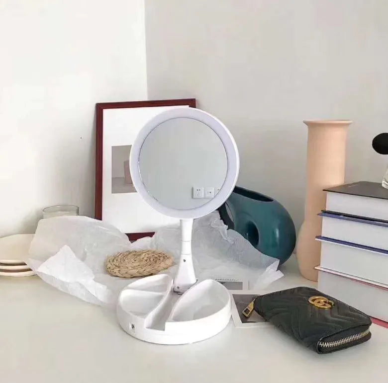 White acrylic LED vanity mirror with double-sided magnification and foldable storage compartments.