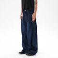 Dark blue washed distressed wide leg machete jeans showing fading and whiskering details
