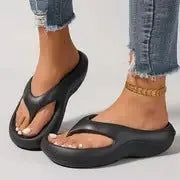 Women's black thick-soled EVA flip-flops with a non-slip patterned sole.