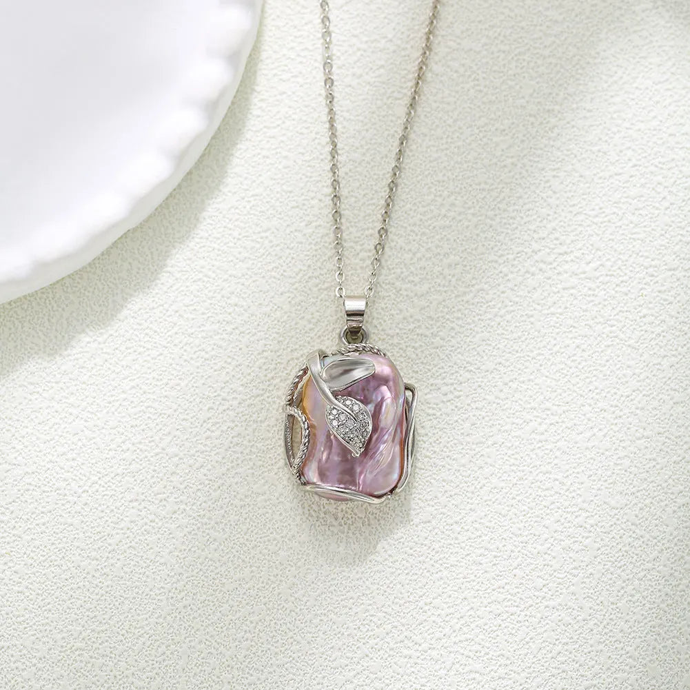 Baroque pendant freshwater pearl necklace clavicle chain with flower leaf motif in Golden Leaves colour, on display