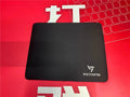 Black thickened rubber mouse pad with rough grain surface texture on desk