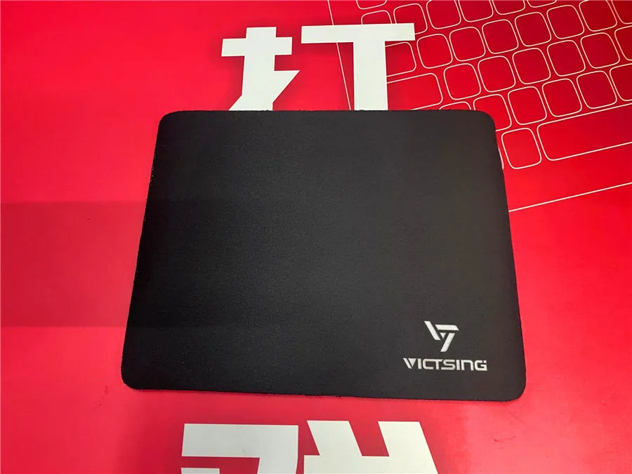 Black thickened rubber mouse pad with rough grain surface texture on desk
